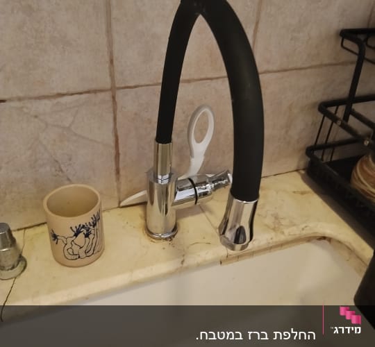 ברז מטבח עם כיור וספל על השיש
